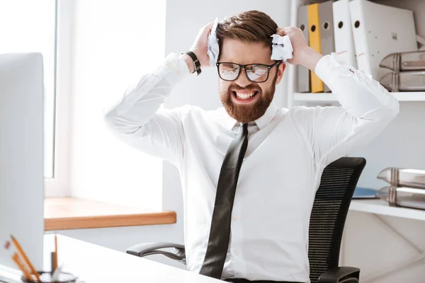 Empresario confuso sentado en la oficina y sosteniendo papel — Foto de Stock