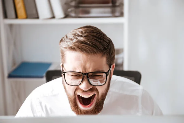 Ουρλιάζοντας θυμωμένος νεαρός επιχειρηματίας ψάχνει στον υπολογιστή. — Φωτογραφία Αρχείου