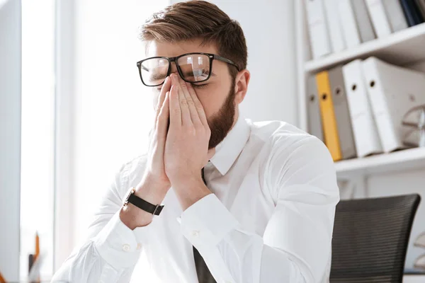 Estresante hombre de negocios en la oficina tocando los ojos . — Foto de Stock