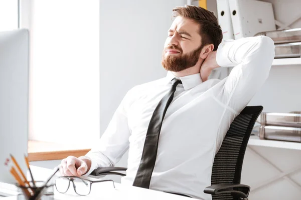 Joven hombre de negocios cansado en la oficina estirándose . — Foto de Stock