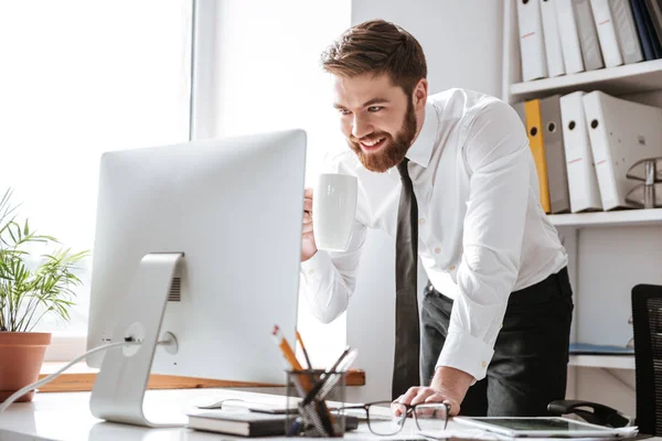 Joven hombre de negocios guapo mirando la computadora . — Foto de Stock