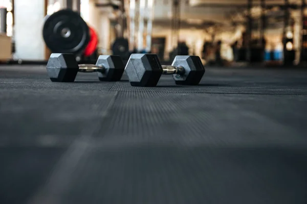 Manubri sul pavimento in palestra — Foto Stock