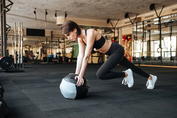 Idrottskvinna träna med boll i gymmet — Stockfoto