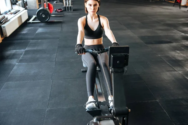 Fitness mujer haciendo ejercicio con la máquina de entrenamiento en el gimnasio — Foto de Stock