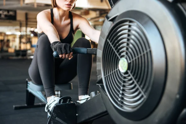 Sportswoman exercising with fitness equipment in gym — Stock Photo, Image