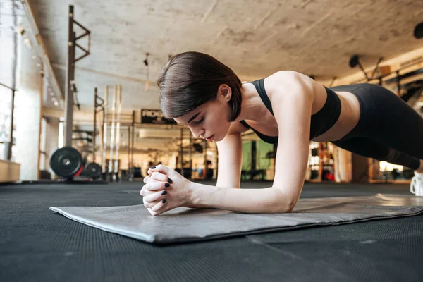 Фитнес-женщина делает упражнения на доске в тренажерном зале — стоковое фото