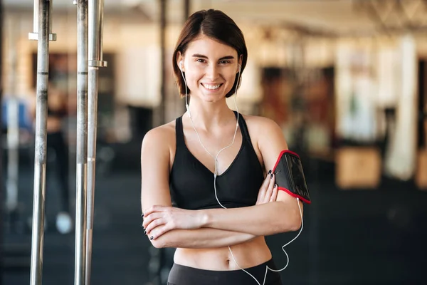 Ευτυχισμένος αθλήτρια με περιβραχιόνιο ακούγοντας μουσική στο γυμναστήριο — Φωτογραφία Αρχείου