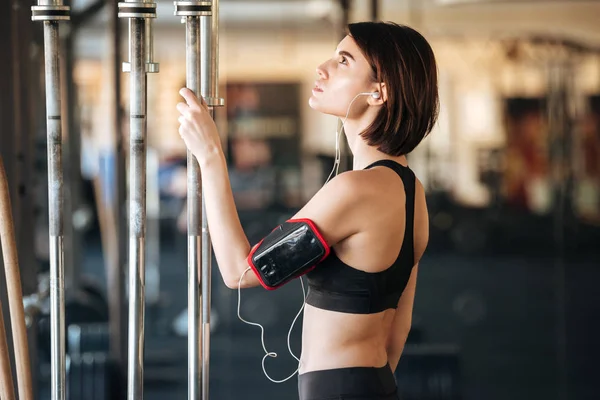 Mujer atleta haciendo ejercicio y escuchando música en el gimnasio — Foto de Stock