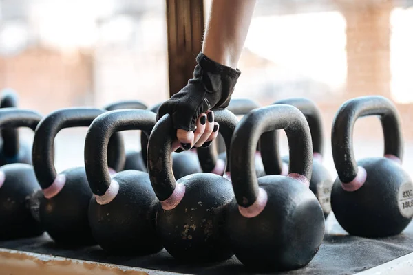 Sportswoman taking kettlebell in gym — Stock Photo, Image