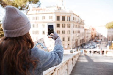 Kadın turist şehirde boş ekran smartphone ile fotoğraf çekmek