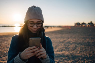 Cep telefonu kullaranarak gözlük bir genç kız portresi