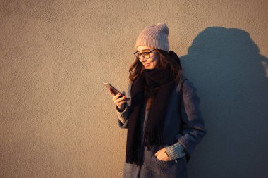 Cep telefonunda mesaj yazarak genç bir kadın portresi