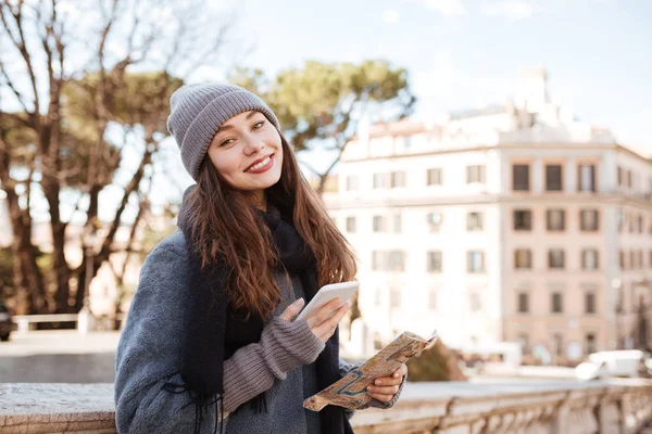 Fröhliche Frau mit Handy und Karte in der Stadt — Stockfoto
