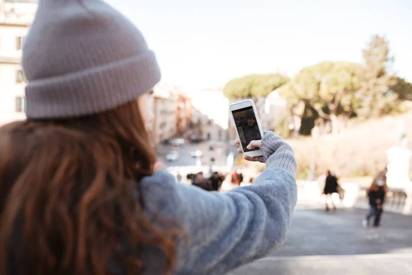 Kvinna att ta bilder med blank skärm mobiltelefon i city — Stockfoto