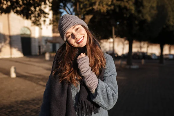 Усміхнена красива молода жінка, що стоїть у місті — стокове фото