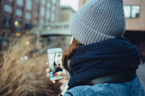 Młoda kobieta biorąc selfie na ulicy — Zdjęcie stockowe