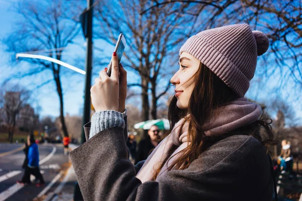 Smiling woman taking photo of a city district — Stock Photo, Image