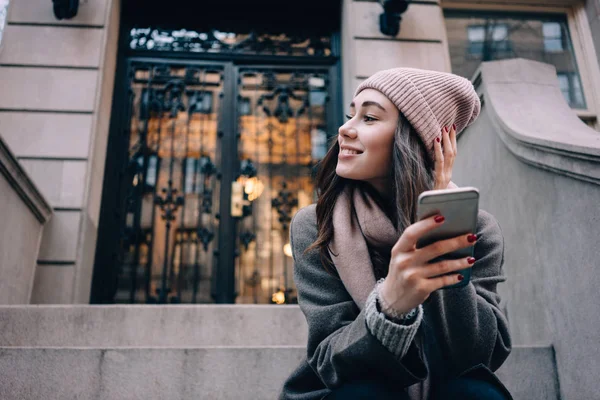 Retrato de cerca de una chica con sombrero sosteniendo el teléfono —  Fotos de Stock