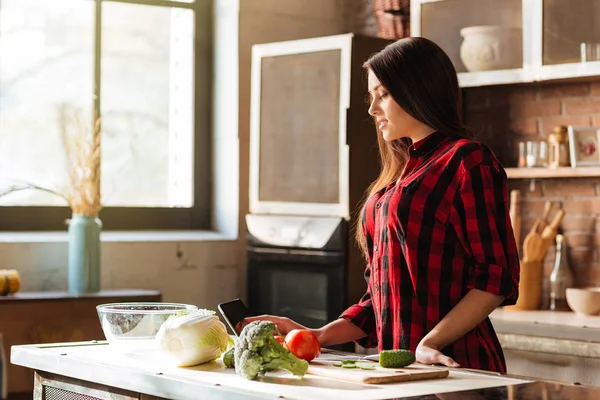 Kobieta stoi w kuchni z komputera typu tablet — Zdjęcie stockowe