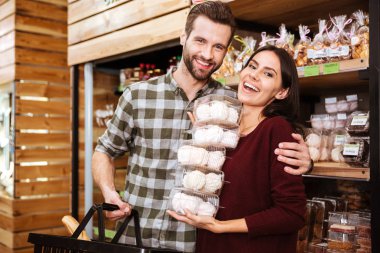 Alışveriş ve marshmalows bakkal dükkanı satın alma yaparken çift