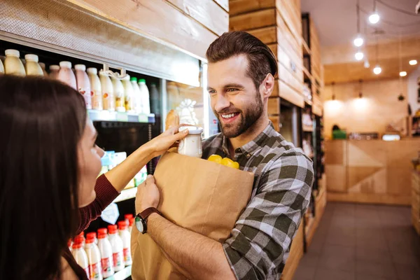 Paar mit Päckchen Lebensmittel im Supermarkt — Stockfoto