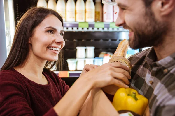 Paar mit Lebensmittelpaket beim Einkaufen im Lebensmittelladen — Stockfoto