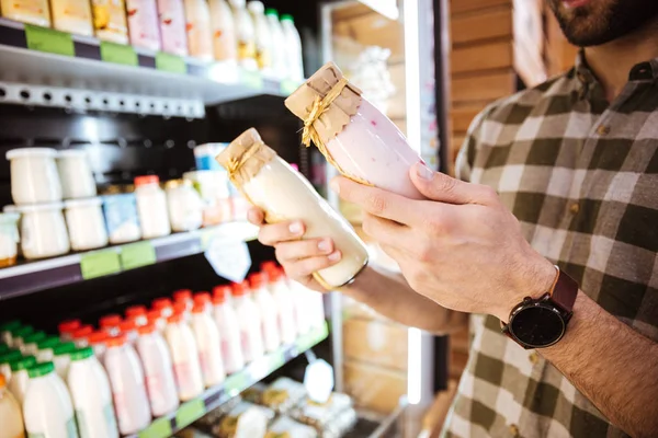Mann steht vor Lebensmittelgeschäft und kauft Joghurt in Flaschen — Stockfoto