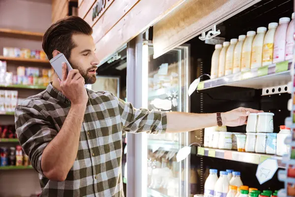 Man talking on mobile phone at shopping in grocery shop