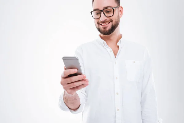 Handsome happy young bearded man chatting by phone — Stock Photo, Image