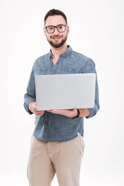 Atractivo joven barbudo hombre utilizando el ordenador portátil — Foto de Stock