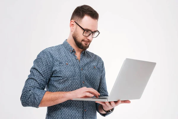 Hombre barbudo joven concentrado usando portátil — Foto de Stock