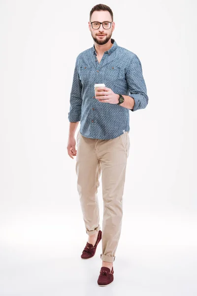 Hombre barbudo guapo de pie con una taza de café — Foto de Stock