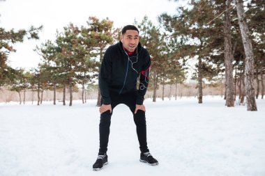 Genç adam kış fitness oturum yaparken bir mola