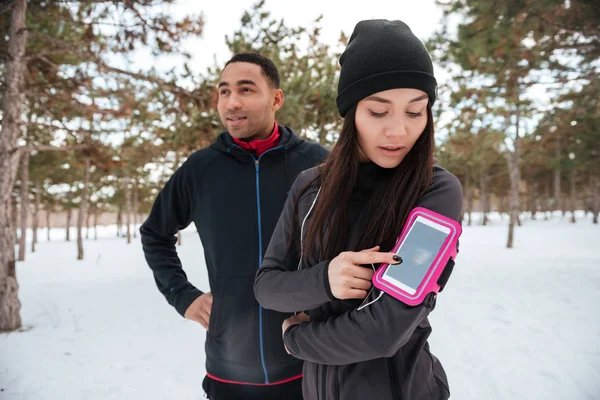 Sports couple getting ready for running marathon in winter forest
