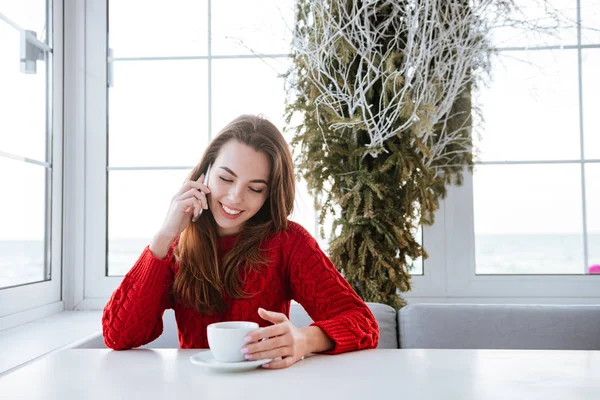 Mujer hablando por teléfono celular y tomando café en la cafetería —  Fotos de Stock