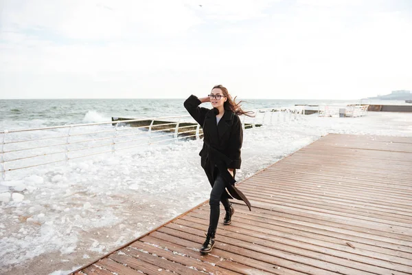 Confiante jeune femme marchant sur la jetée en hiver — Photo