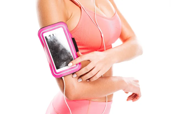 Femme de remise en forme toucher écran vierge téléphone portable dans le brassard — Photo