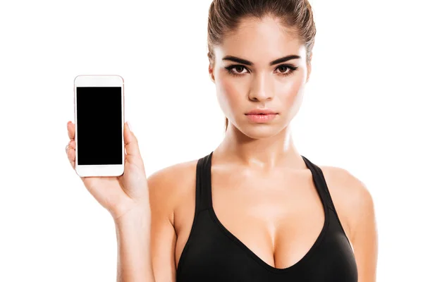 Atrakcyjna młoda fitness kobieta wyświetlone puste smartphone ekran — Zdjęcie stockowe