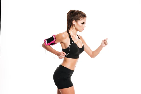 Jovem bela mulher fitness correndo e ouvindo música — Fotografia de Stock