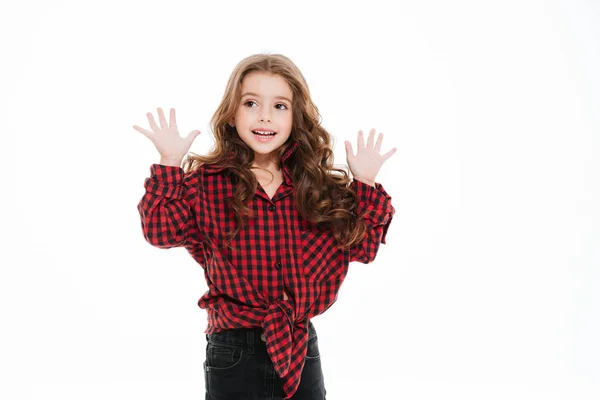 Усміхнена маленька дівчинка в плетеній сорочці, що стоїть з піднятими руками — стокове фото
