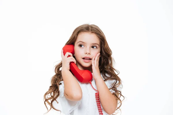Surpreendido encantadora menina ligando e falando no telefone vermelho — Fotografia de Stock