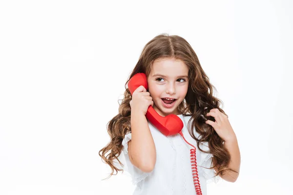 Portret bardzo kręcone dziewczynka rozmawia czerwony telefon — Zdjęcie stockowe