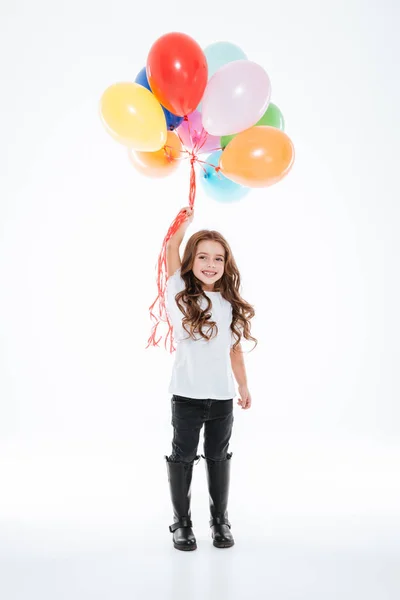 Longitud completa de niña sonriente sosteniendo globos de colores —  Fotos de Stock