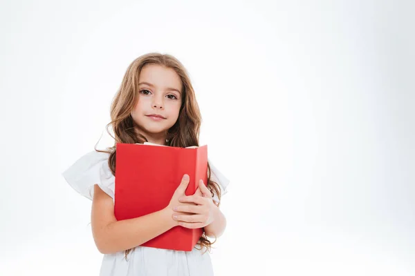 Γοητευτικό κορίτσι στέκεται και κρατώντας κόκκινο βιβλίο — Φωτογραφία Αρχείου