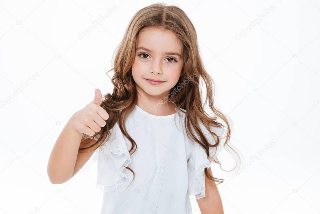 Happy cute little girl standing and showing thumbs up