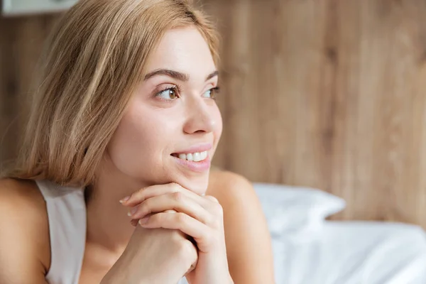 Alegre hermosa mujer joven relajándose en la cama en el dormitorio —  Fotos de Stock