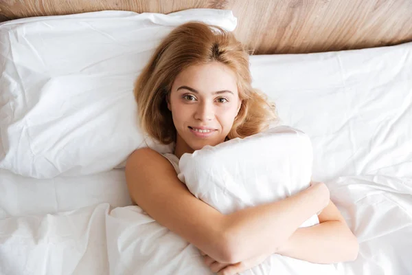 Vista superior de la mujer sonriente corriendo con almohada —  Fotos de Stock