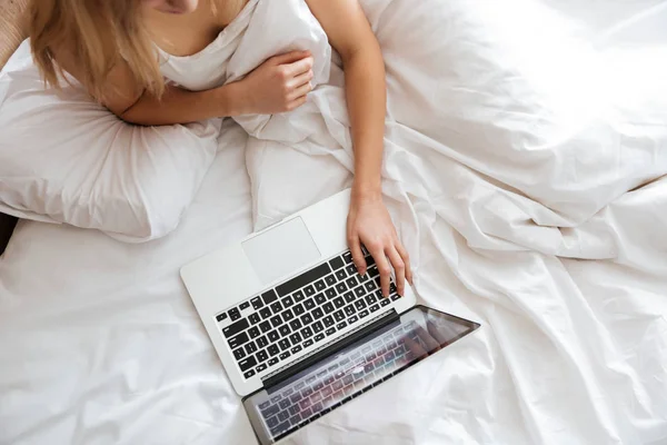 Imagem cortada de mulher usando laptop na cama — Fotografia de Stock