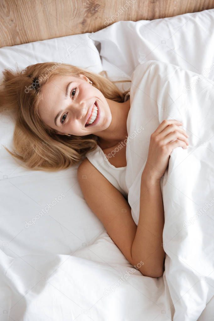 Top view of woman on bed and looking at camera