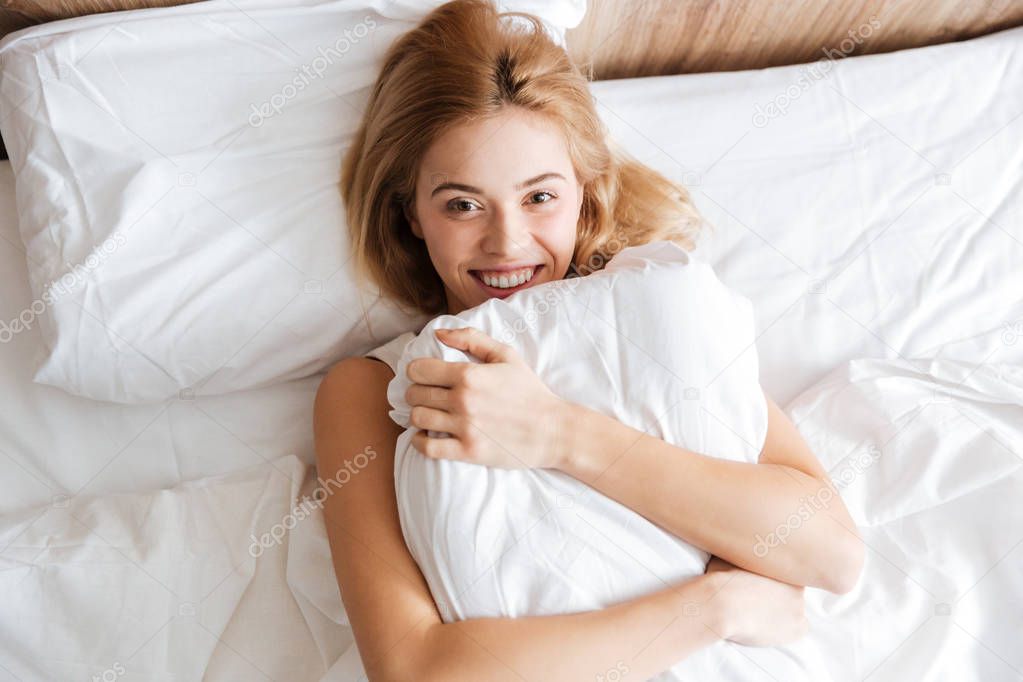 Top view of Happy woman emracing with pillow